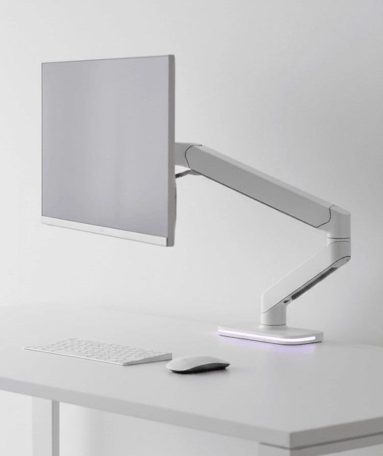 Computer monitor on a stand with keyboard and mouse on a white desk